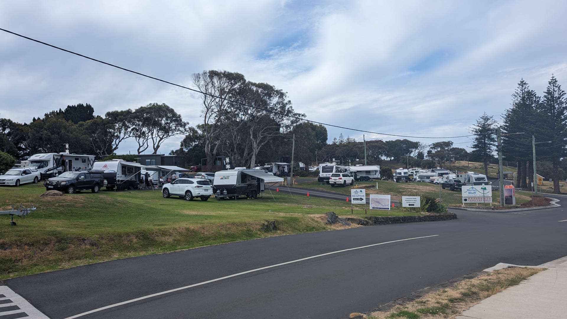 Caravan park in Australia with vehicles and trees.